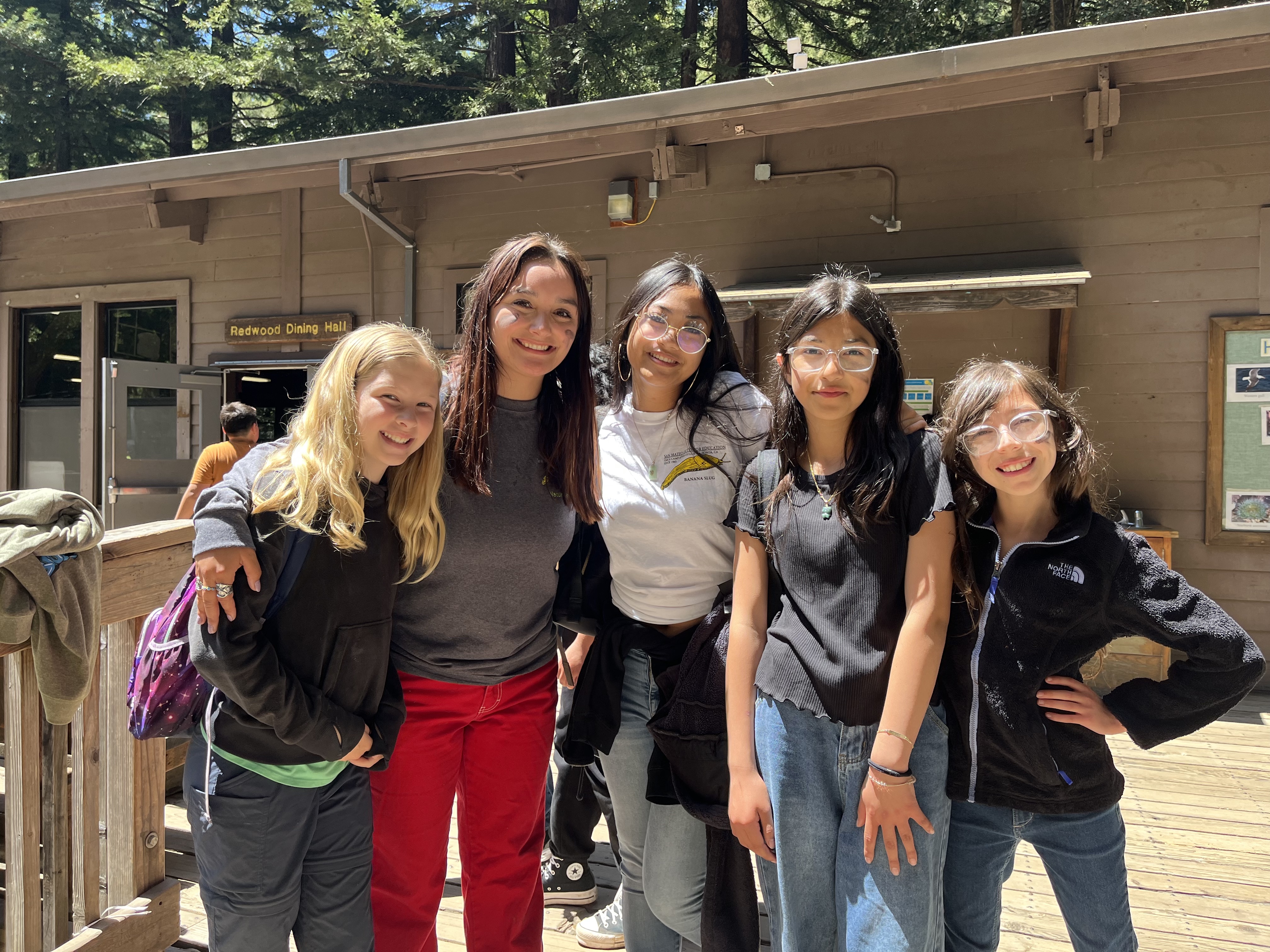 A naturalist posing with students and a cabin leader