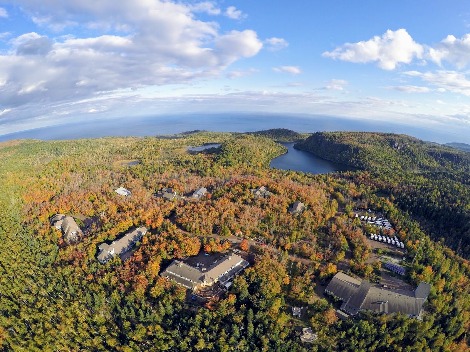 A birds eye view of the Wolf Ridge Campus. The campus is wooded with 2 lakes on the property and a view of Lake Superior.